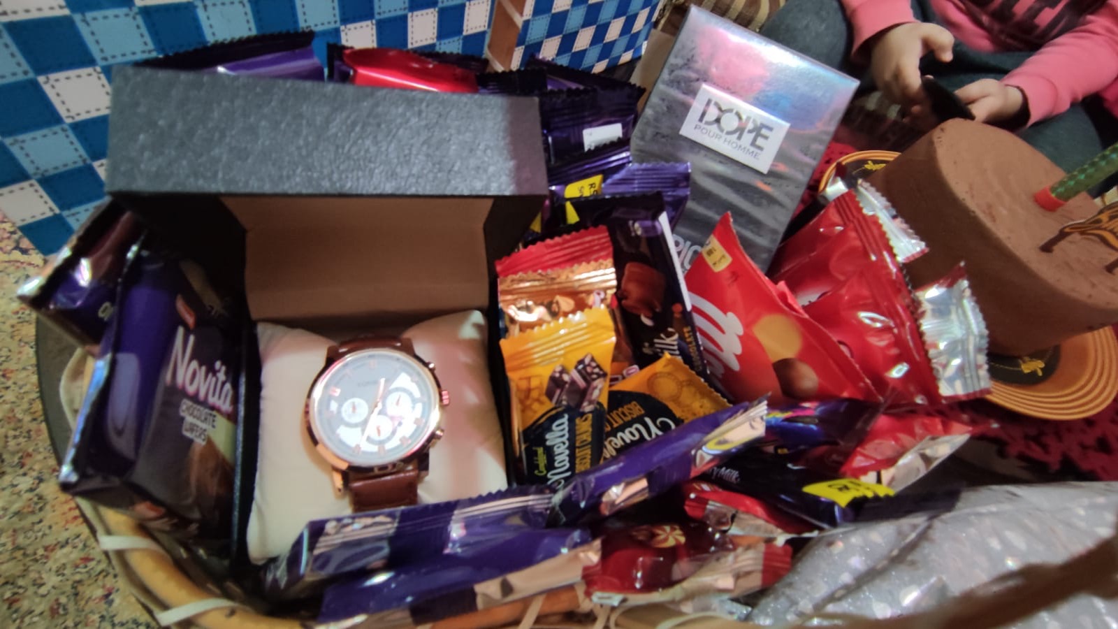Basket with watch, wallet and chocolates